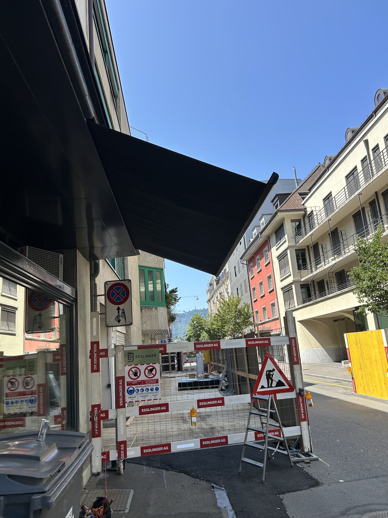 Montage einer dunklen Markise an einem Gebäude in einer Altstadtgasse